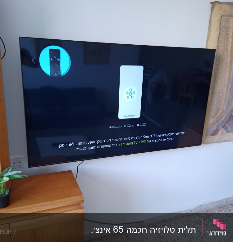 טלוויזיה תלויה על הקיר עם כבלים חשמליים גלויים